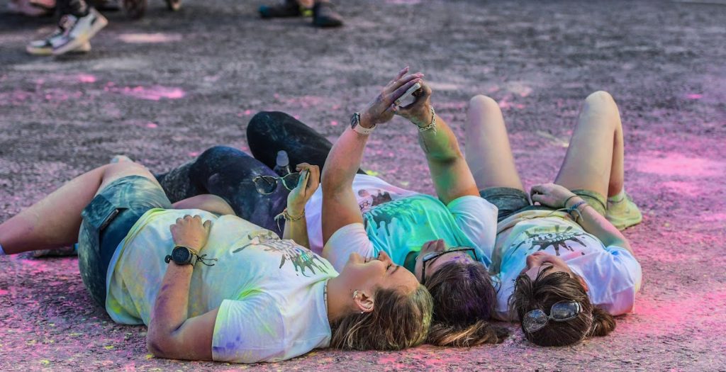 Colour Rush runners lyingon the ground covered in powder paint at Devizes Colour Rush