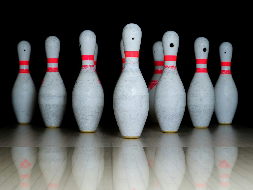 A group of slightly tatty skittles / bowling pins. Photo by Engin Akyurt via unsplash